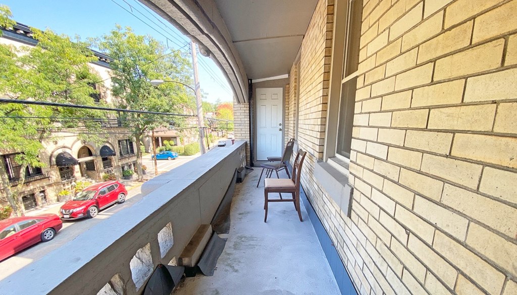 a balcony with two chairs and a view of the street