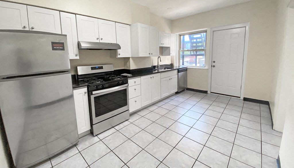 a kitchen with white cabinets and a stainless steel refrigerator