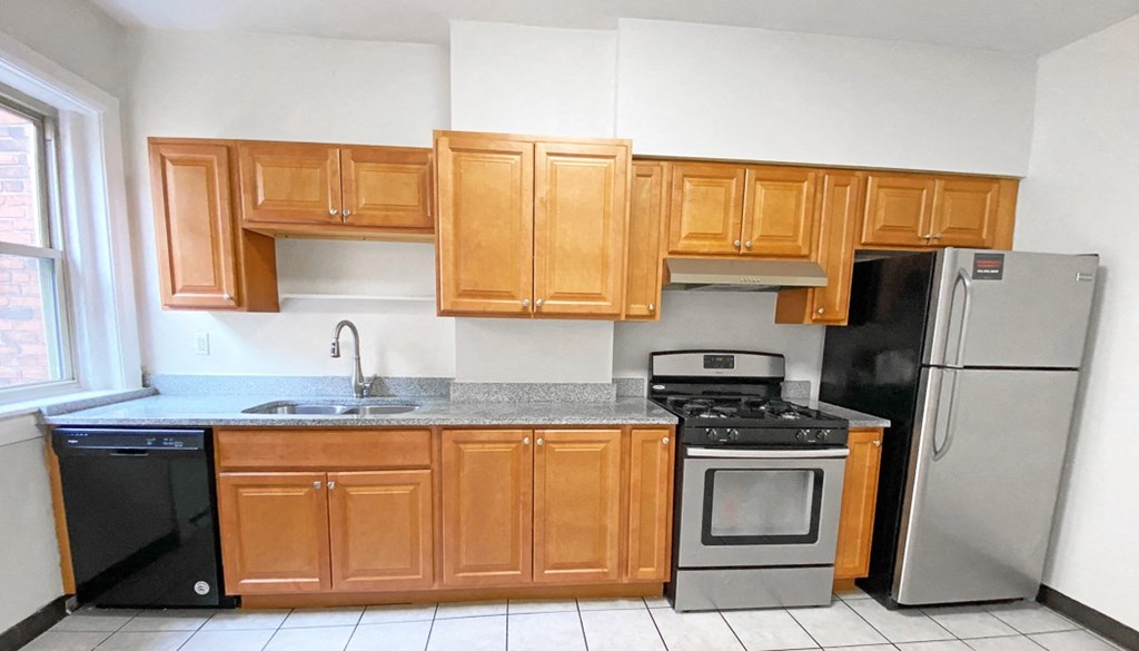 a kitchen with wooden cabinets and stainless steel appliances