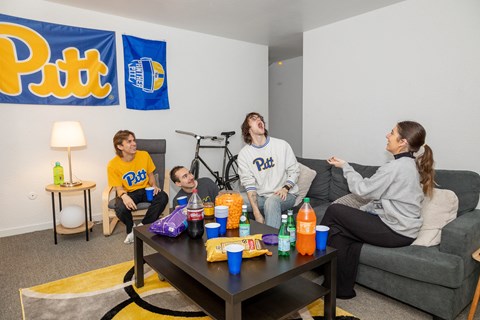 a group of people sitting around a coffee table at University Commons Apartments, Oakland, Pittsburgh