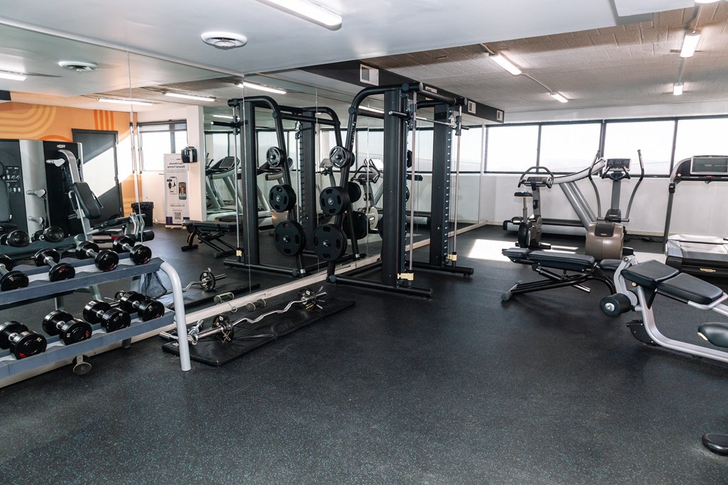 A gym with a variety of equipment including weights and weight machines at Walnut Towers at Frick Park, Pennsylvania