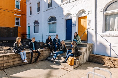 a group of people sitting on the steps of a building at University Commons Apartments, Oakland, Pittsburgh