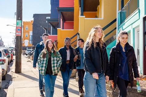 a group of young people walking down a street at University Commons Apartments, Oakland, Pittsburgh