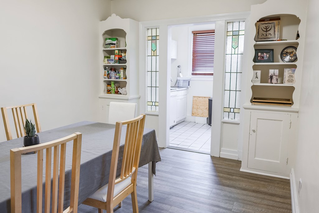 A dining room with a table and chairs.