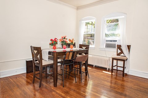A dining room with a wooden table and chairs.