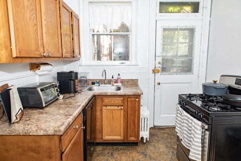 A kitchen with wooden cabinets and a black stove top.