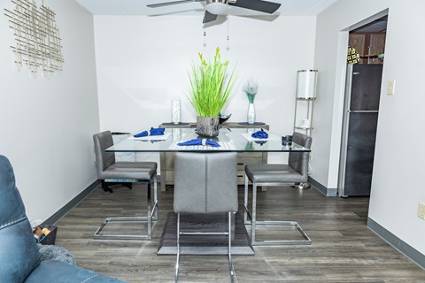A dining room with a table set for two and a blue couch. at Walnut Crossings, Monroeville, PA, 15146