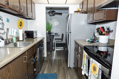 A kitchen with wooden cabinets and a stainless steel refrigerator. at Walnut Crossings, Monroeville, PA, 15146