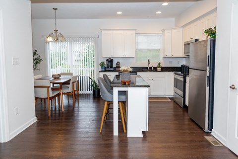 A kitchen with a dining table and chairs.