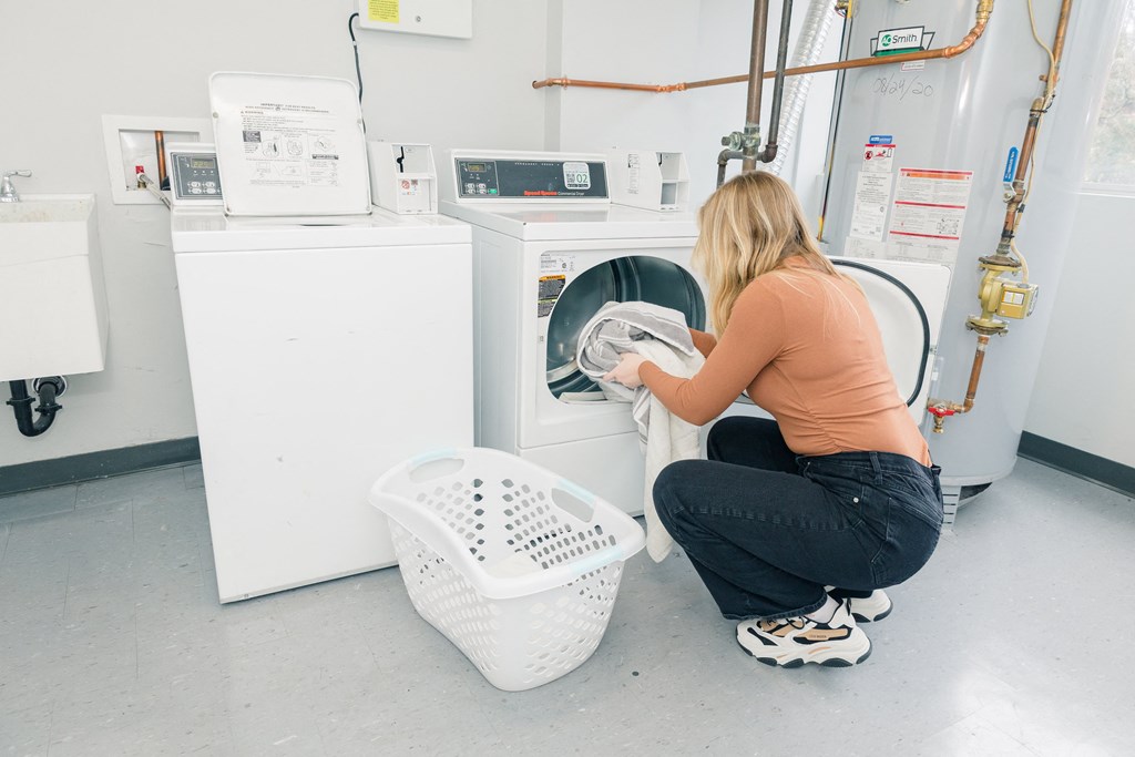 A woman is doing laundry in a laundromat at Walnut Towers at Frick Park, Pennsylvania 15217