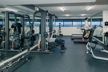 A gym with people working out and a man on a treadmill at Walnut Towers at Frick Park, Pittsburgh, PA