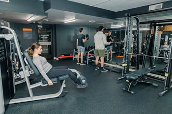 A woman is working out on a leg press machine in a gym at Walnut Towers at Frick Park, Pittsburgh, 15217