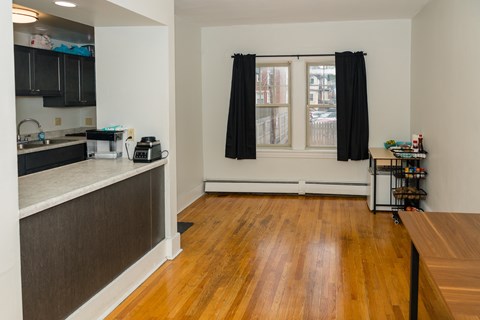 A kitchen with black cabinets and a wooden floor.