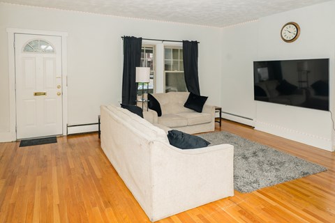 A living room with a white couch and a television.