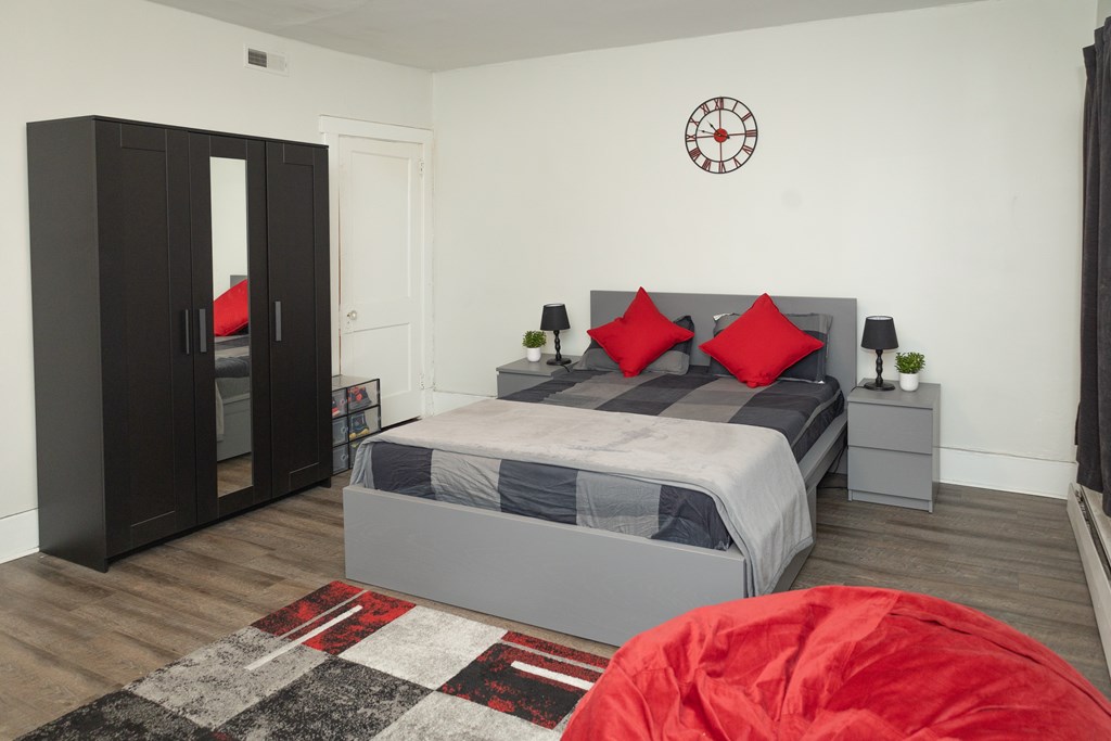 A bedroom with a bed, nightstands, and a wardrobe.