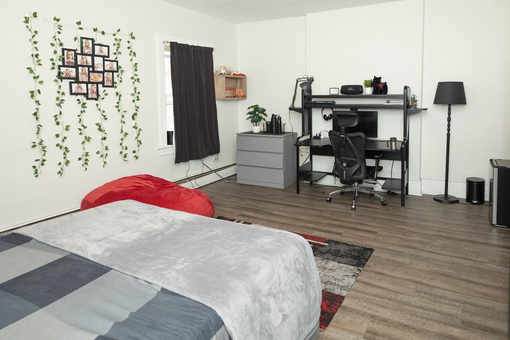 A bedroom with a bed, desk, and chair.