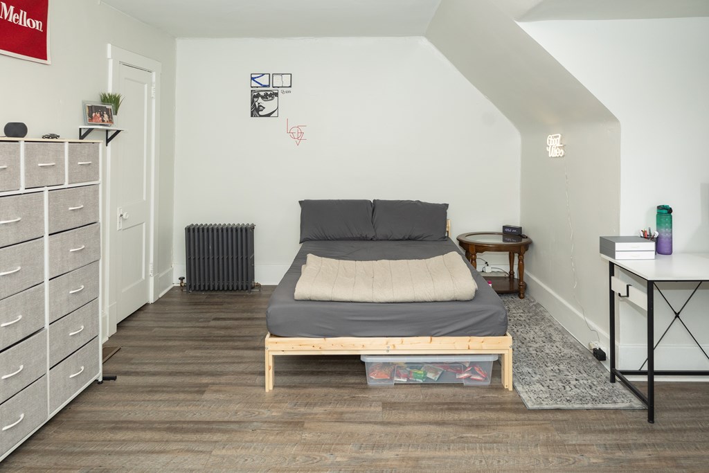 A bedroom with a bed, nightstand, and a dresser.