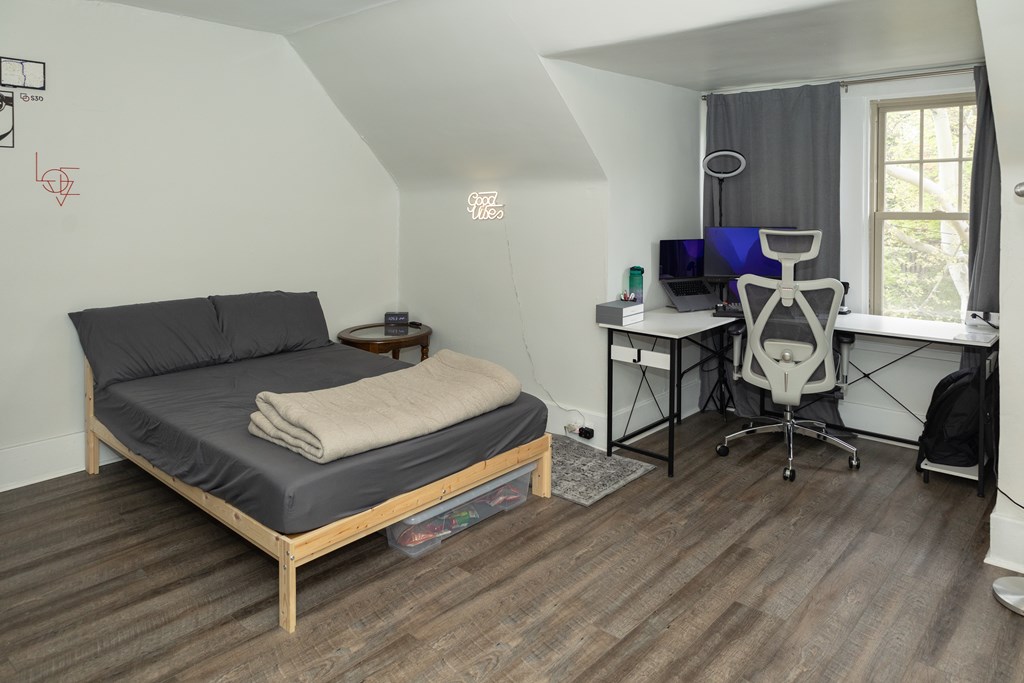 A bedroom with a bed, desk, and chair.