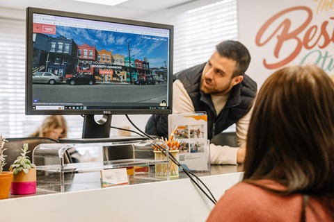 a man and a woman sitting at a desk in front of a computer monitor at University Commons Apartments, Oakland, Pittsburgh