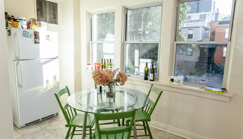 a kitchen with a glass table and green chairs
