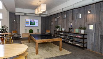 a game room with a ping pong table and a flat screen tv