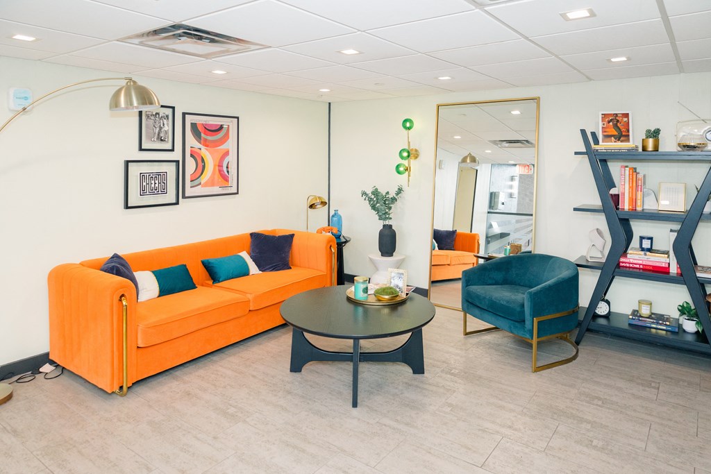 A living room with a sofa, armchair, and coffee table at Walnut Towers at Frick Park, Pittsburgh