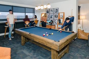 A group of people playing pool in a room at Walnut Towers at Frick Park, Pennsylvania