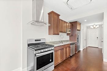a kitchen with wood cabinets and stainless steel appliances at The Washington at Chatham, Pennsylvania