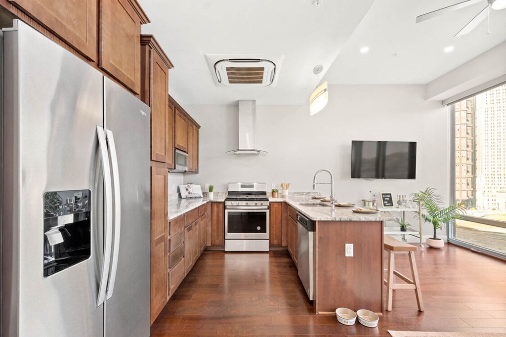 a kitchen with wood cabinetry and white walls at The Washington at Chatham, Pittsburgh