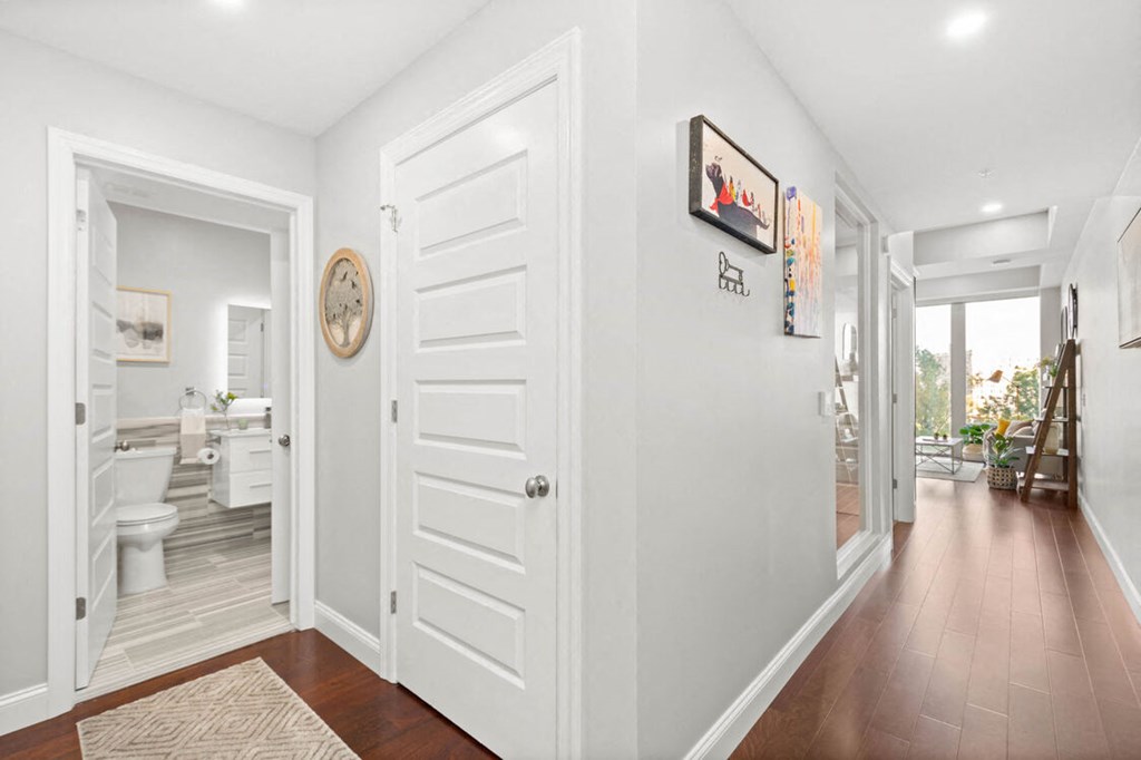 a hallway with a white door and hardwood floors at The Washington at Chatham, Pennsylvania, 15219