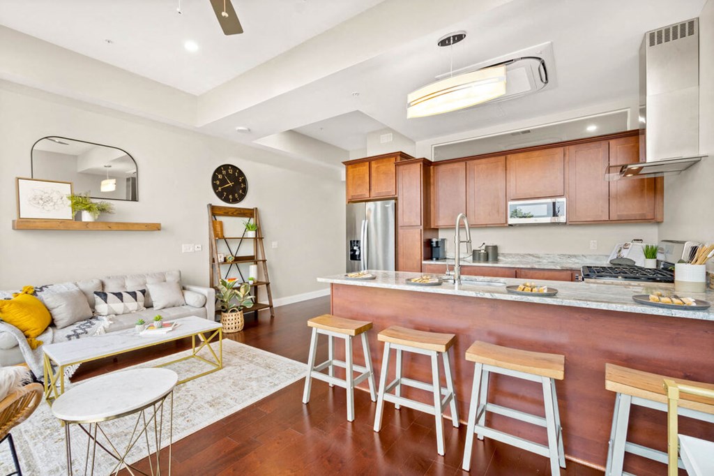 a kitchen with a long counter and a living room with a couch at The Washington at Chatham, Pittsburgh, PA 15219
