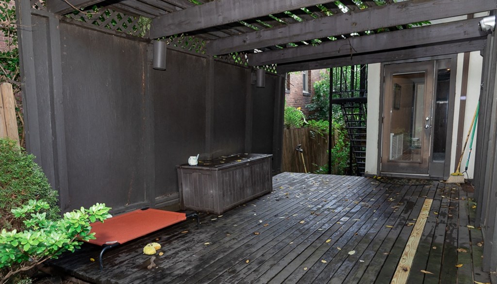 a deck with a hot tub and a pergola