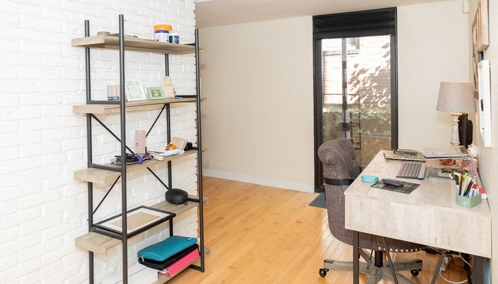 a home office with a desk and a bookshelf