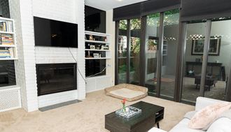 a living room with a fireplace and sliding glass doors