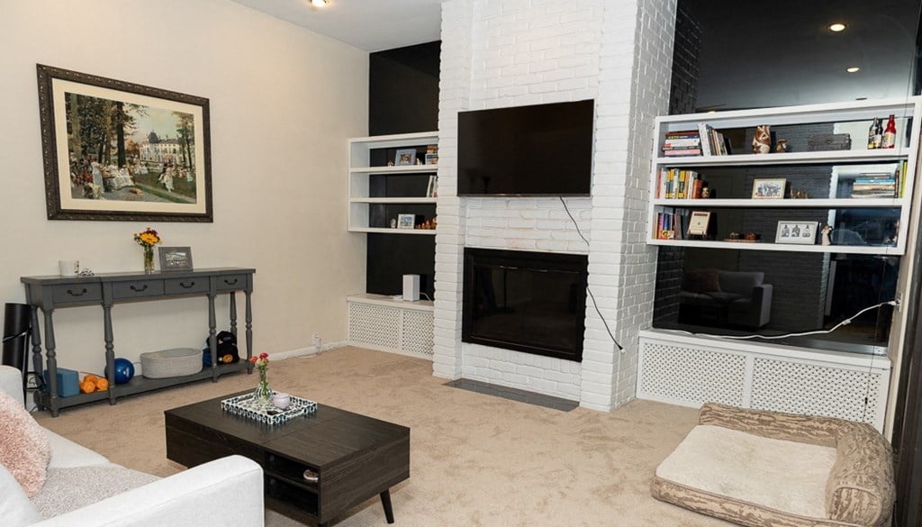 a living room with a fireplace and a tv on the wall