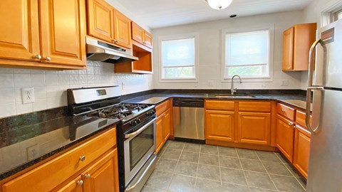 a kitchen with wooden cabinets and stainless steel appliances