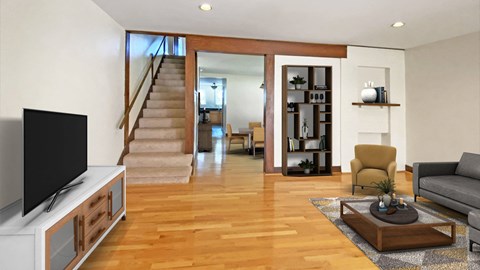 a view from the living room into the kitchen and stairs to the bedrooms