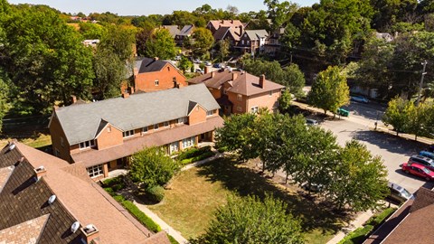 arial view of a large brick home with a grey roof
