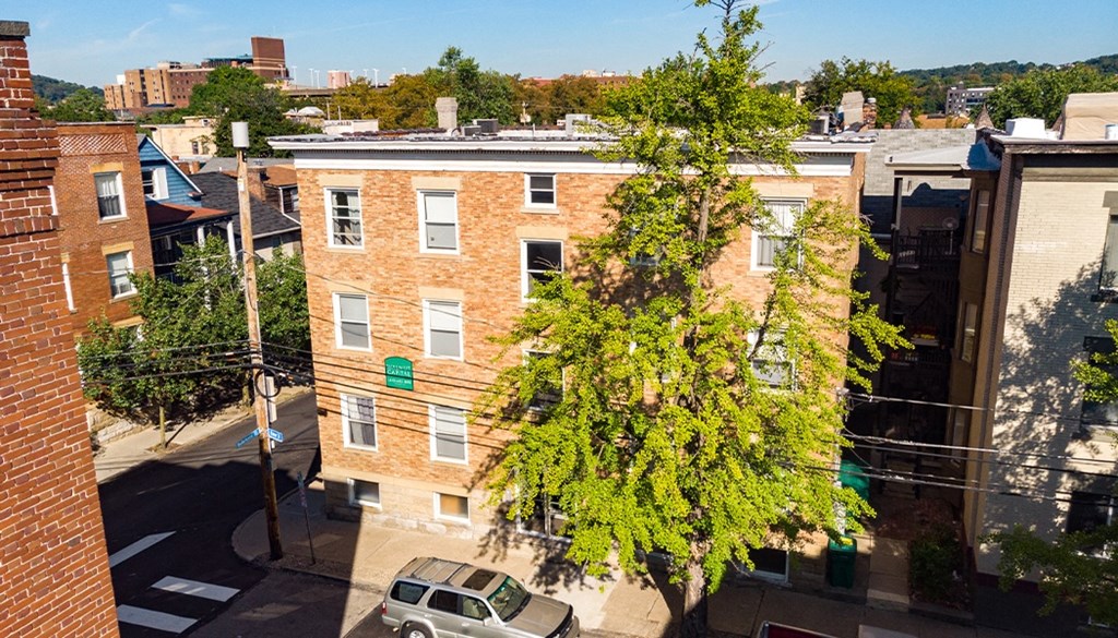 an aerial view of a brick apartment building with a car parked in front of it