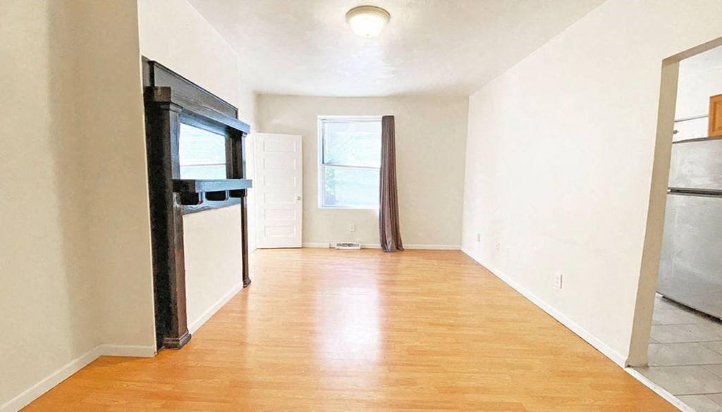 an empty room with a stove and a window