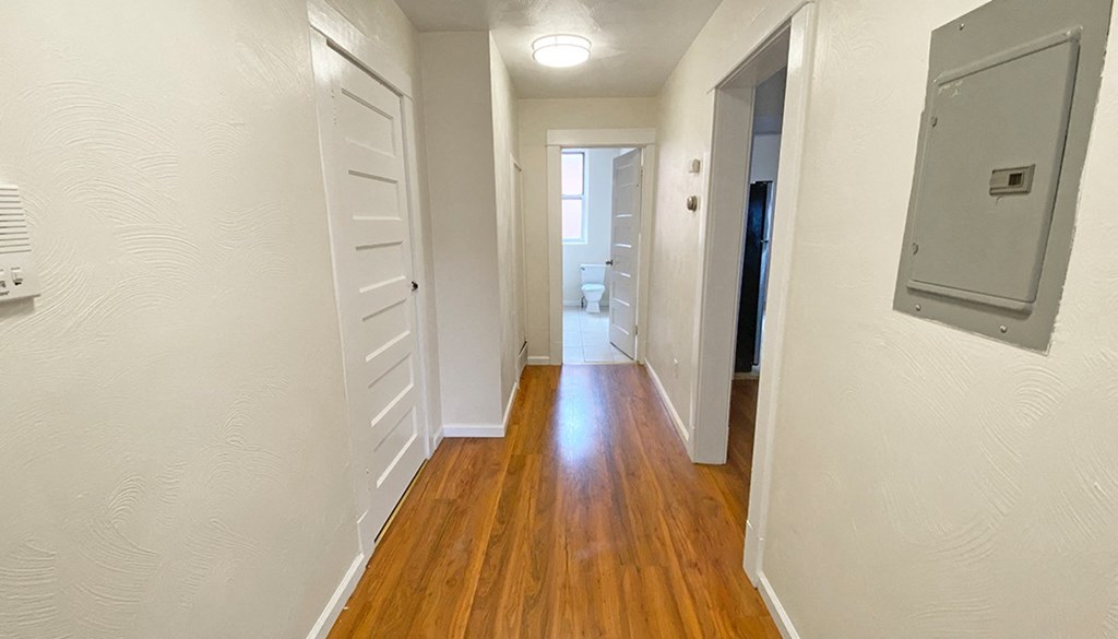 a hallway with wood floors and white walls