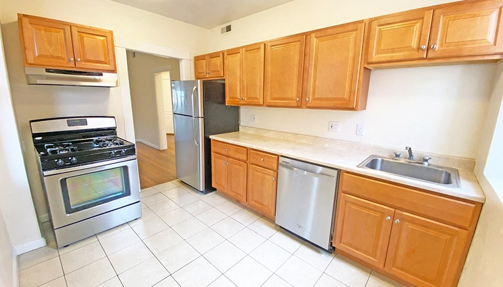 a kitchen with wooden cabinets and stainless steel appliances