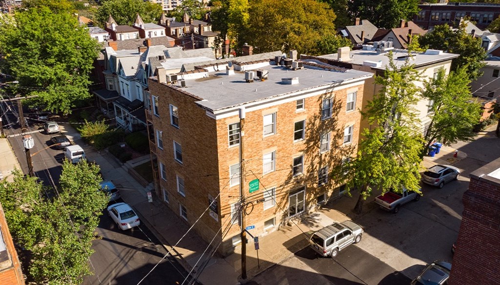 an aerial view of a brick apartment building with a gray roof