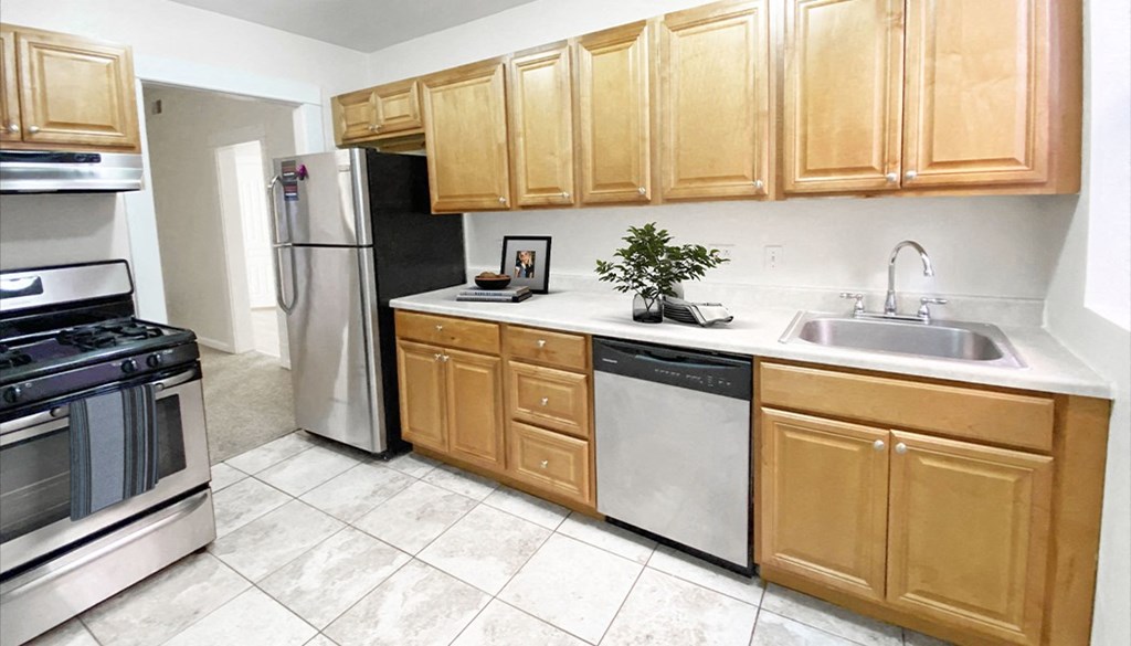 a kitchen with wooden cabinets and stainless steel appliances