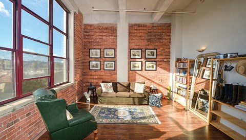 A living room with a green chair and a couch.