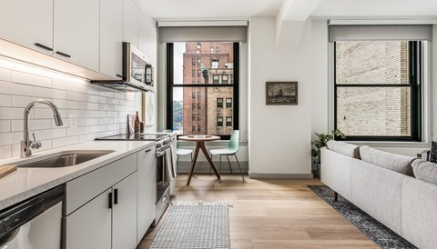 One Bedroom Apartment a kitchen with white cabinets and a sink and a window at The Commonwealth Building, Pittsburgh