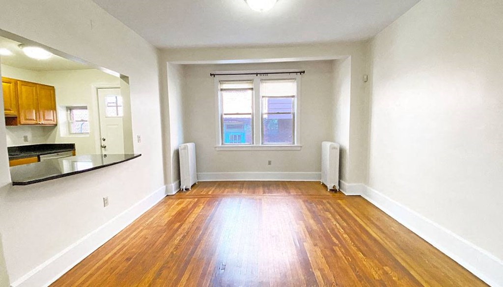 an empty room with white walls and wood floors