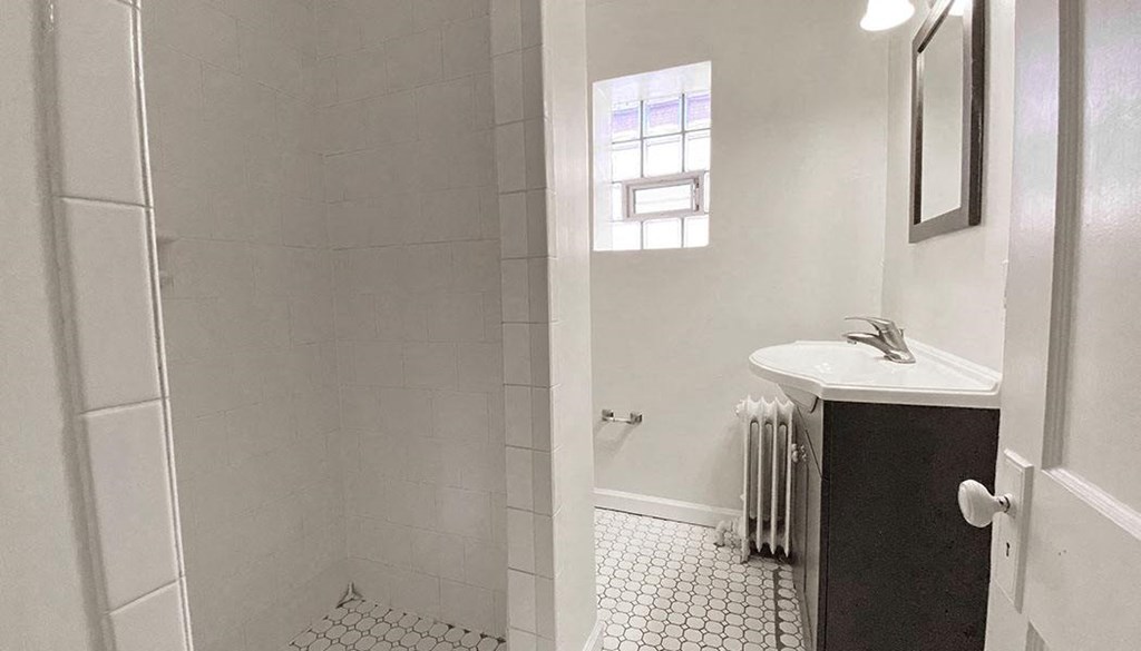 a white bathroom with a sink and a shower