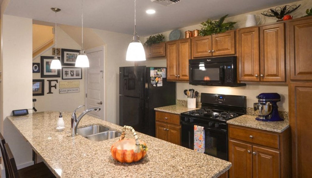 a kitchen with a granite counter top and black appliances