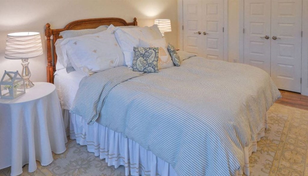 a bed with a blue and white comforter and pillows